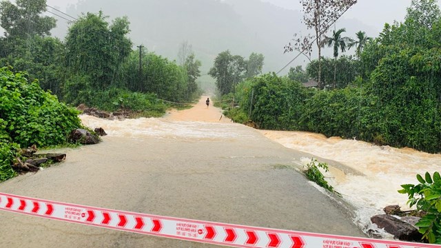 Lực lượng chức năng căng dây cảnh báo tại khu vực đường bị ngập tại thôn Dỗi, xã Thượng Lộ, huyện Nam Đông.