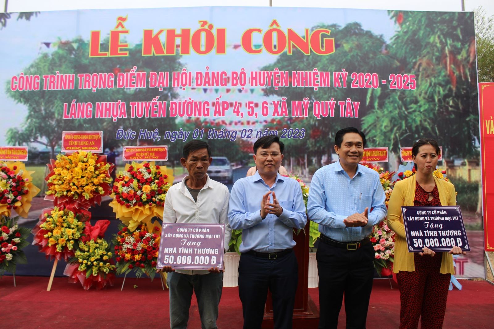 Ông Trần Thanh Phong - Bí thư huyện ủy Đức Huệ (thứ hai, từ phải qua) tặng biểu trưng hai căn nhà tình thương cho hộ nghèo ở xã Mỹ Quý Tây