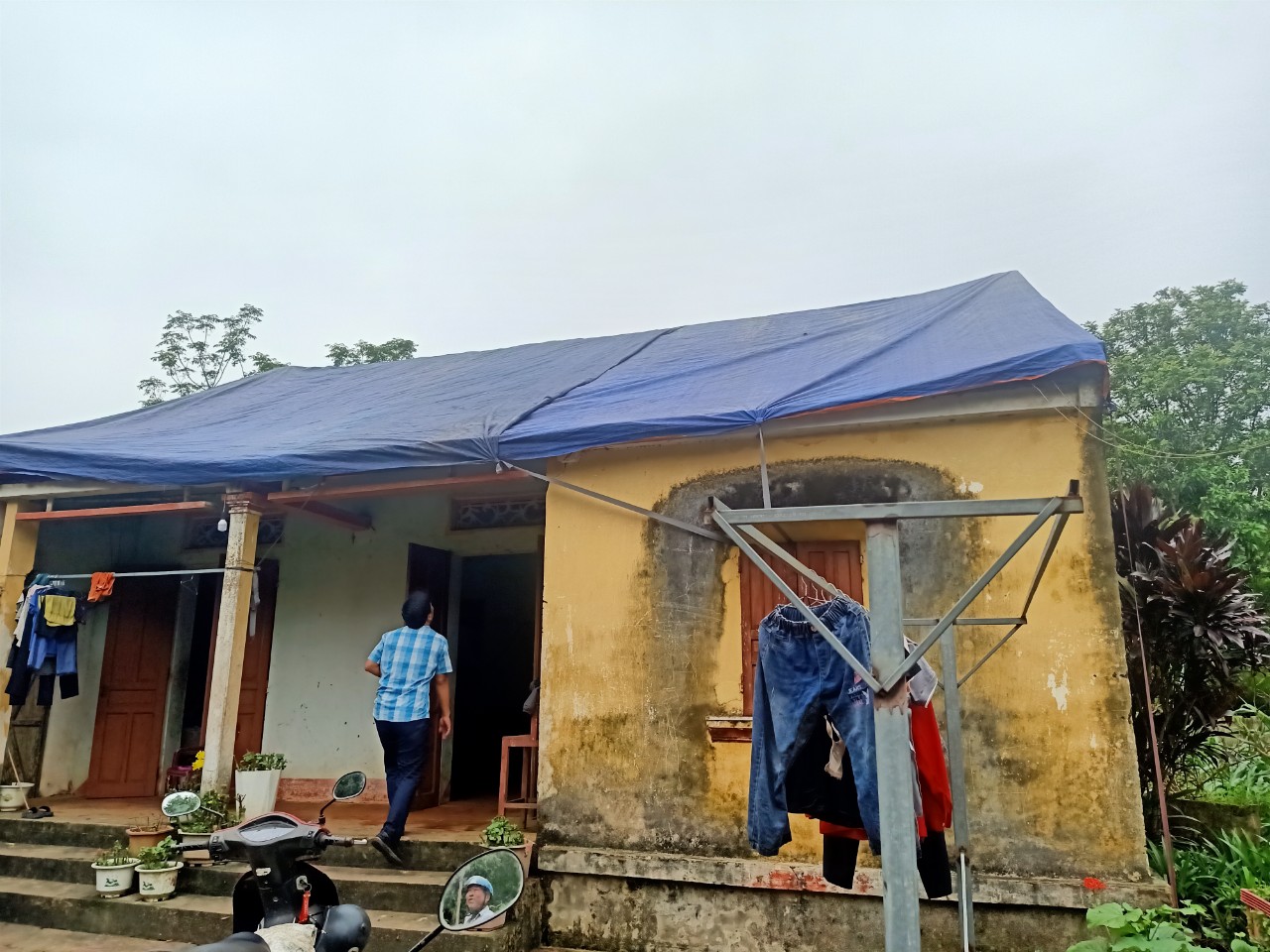Ngôi nhà lợp bằng mái ngõi cũ tại xã Xuân Hưng bị mưa đá làm hư hỏng toàn bộ phải dùng bạt để bao phủ