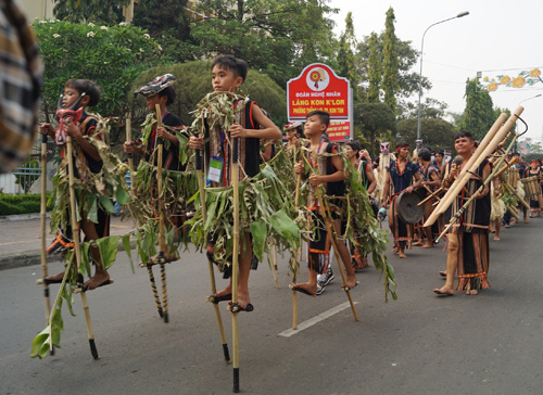Hàng trăm học sinh hóa trang lá cây quanh cơ thể, đeo mặt nạ- biểu tượng thần linh che chở bản làng mình phía trước ngực, đi cà kheo suốt hơn 1 km trên đường phố Kon Tum.