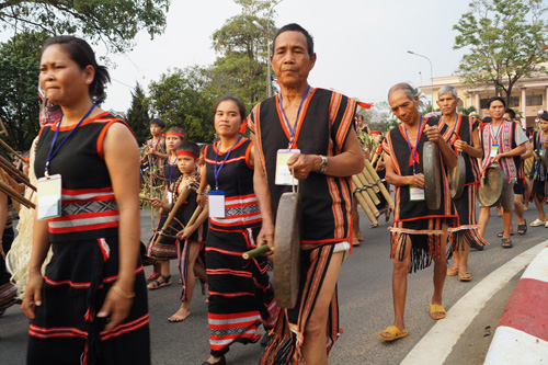 Những chàng trai mặc khố, các cô gái mặc váy được làm từ vỏ cây rừng tham gia lễ hội văn hóa dân gian Tây Nguyên trên đường phố.
