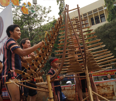 Nghệ nhân Ka Ly Tran(28 tuổi, ngụ  phường Thắng Lợi, TP Kon Tum) say sưa chơi đàn T'rưng trên đường phố.