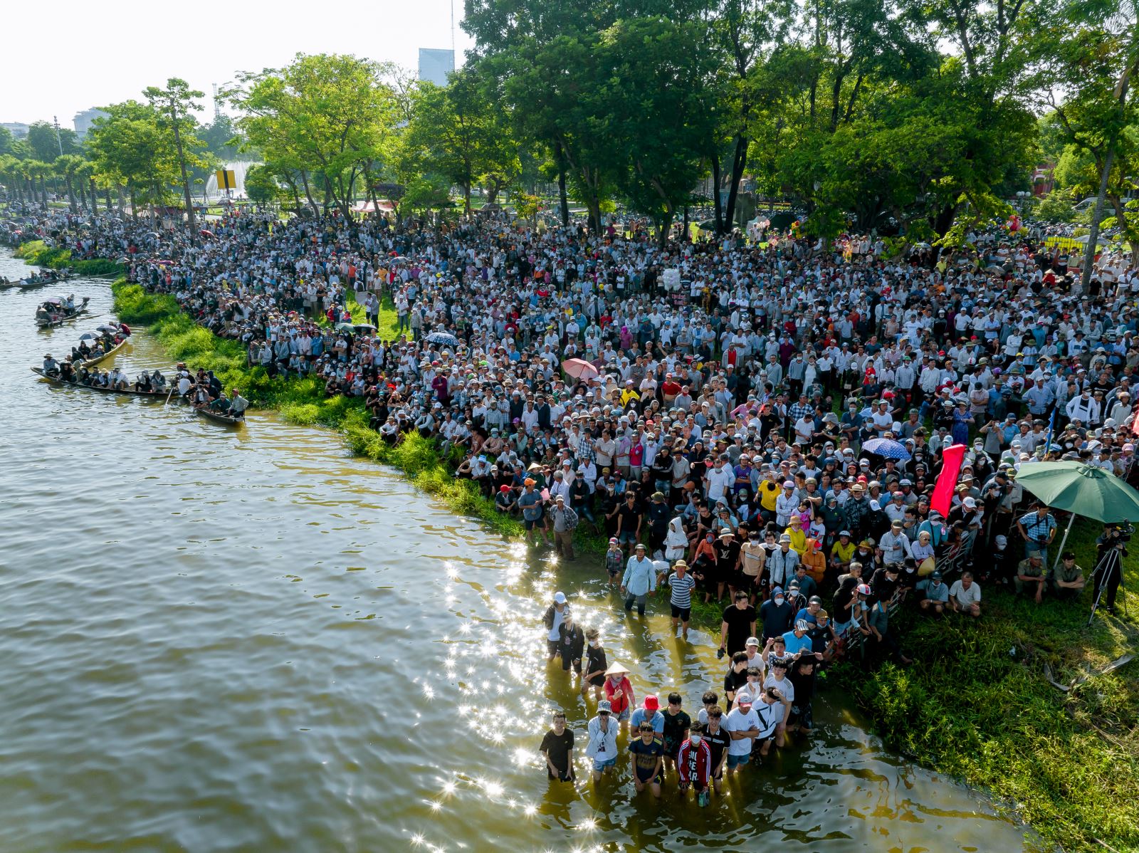 Hàng nghìn người dân cùng du khách hội tụ về cùng reo hò náo nhiệt ở hai bên bờ sông Hương để cổ vũ cho những tay chèo.
