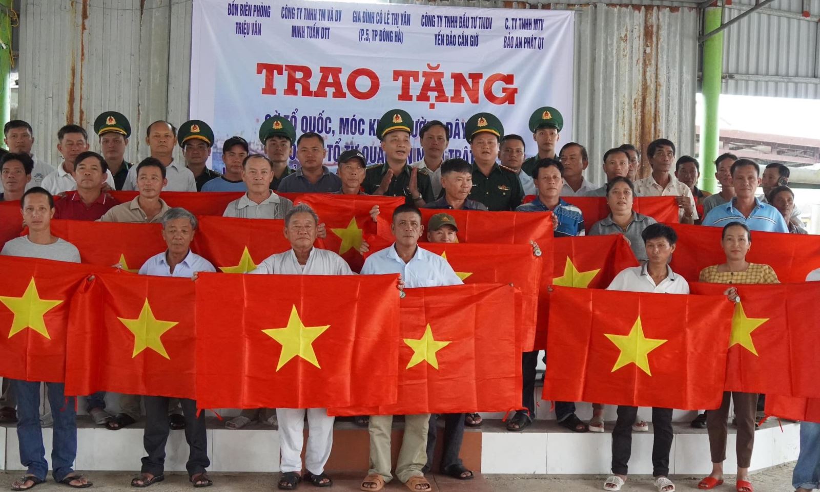 Bộ đội Biên phòng Quảng Trị trao hàng ngàn cờ Tổ quốc và móc khóa “đường dây nóng” cho người dân.