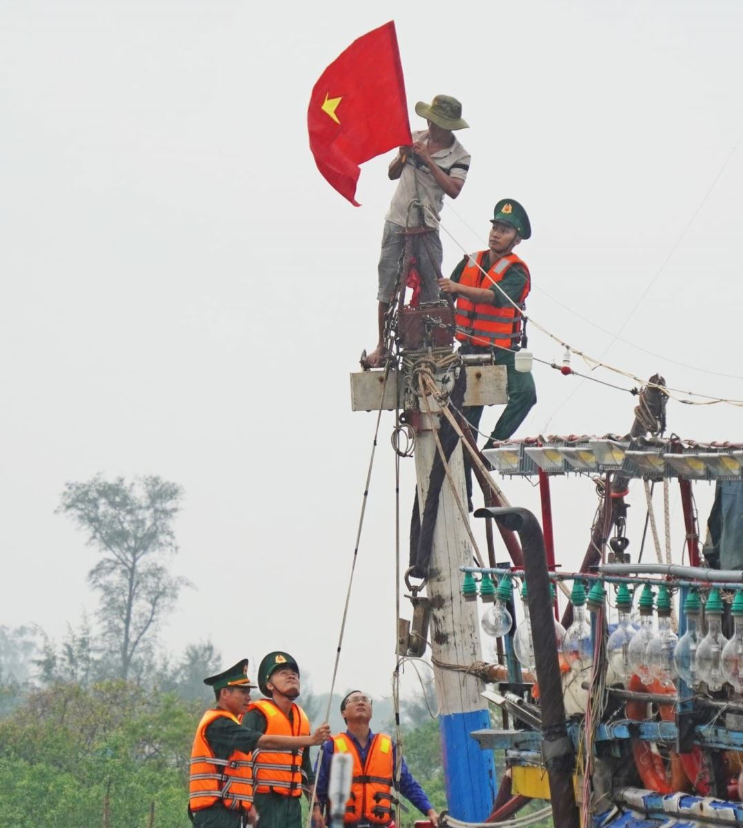 Bộ đội Biên phòng Quảng Trị treo cờ tổ quốc lên tàu đánh cá cho ngư dân.