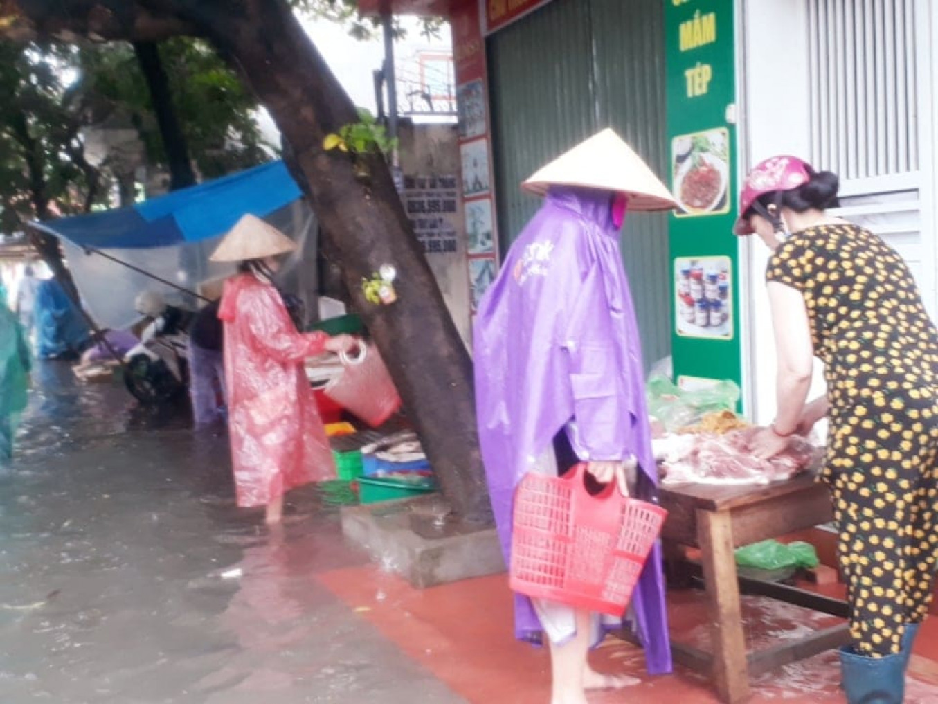 Người dân đi chợ cũng gặp khó khăn do mưa lớn.