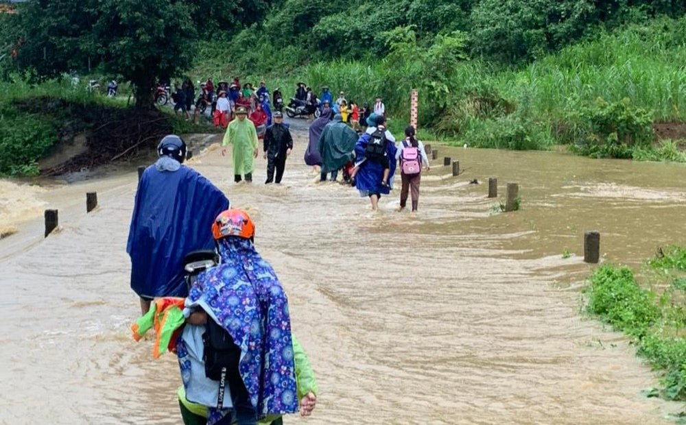 Lực lượng chức năng huyện Quỳ Hợp hướng dẫn người dân qua lại các điểm bị ngập lụt