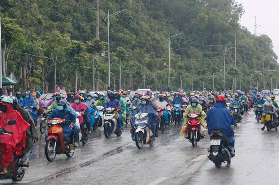 Ngày 5/10, hàng trăm người đi xe máy “chạy mưa” , chở người thân và hành lý nối đuôi nhau chạy qua chốt kiểm soát cầu Bến Thủy (Nghệ An).