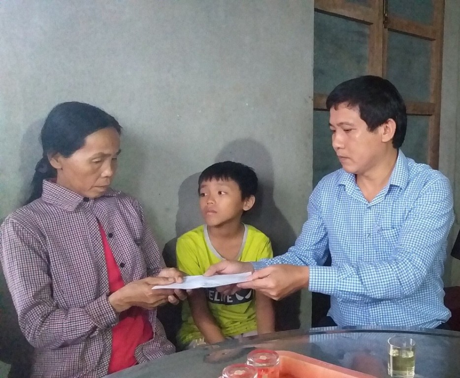 Ông Trần Duy Cường, Giám đốc Chi nhánh NHCSXH Quảng Ngãi thăm và tặng quà cho gia đình có người chết tại xã Hành Trung, huyện Nghĩa Hành