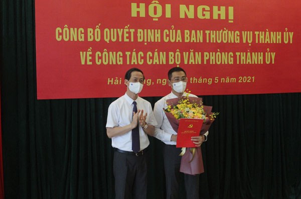 Ông Đỗ Mạnh Hiến, Phó Bí thư Thường trực Thành ủy trao Quyết định và tặng hoa cho ông Bùi Văn Kiệm.