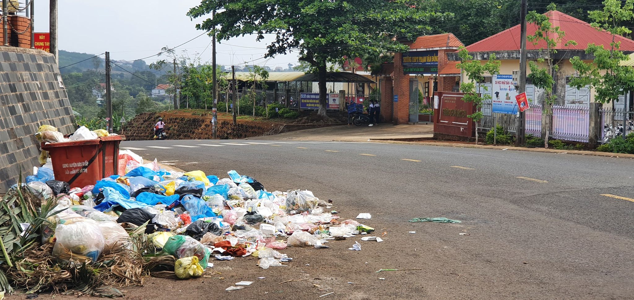 Rác thải chất đống trước cổng trường THPT Phạm Văn Đồng, ngay cạnh Quảng trường của huyện Đắk R'lấp.