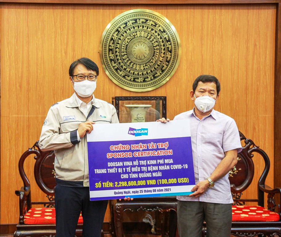 TGĐ Doosan Vina Jeong Young Chil (trái) trao biểu trưng hỗ trợ số tiền gần 2,3 tỉ đồng cho Chủ tịch UBND tỉnh Quảng Ngãi Đặng Văn Minh.